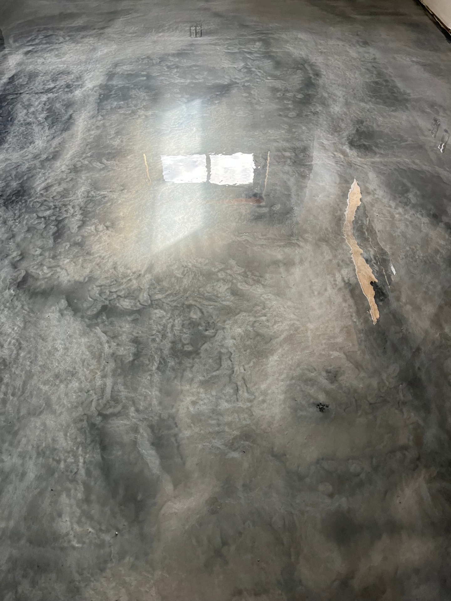 Polished metallic epoxy floor with swirling pearl and charcoal finish